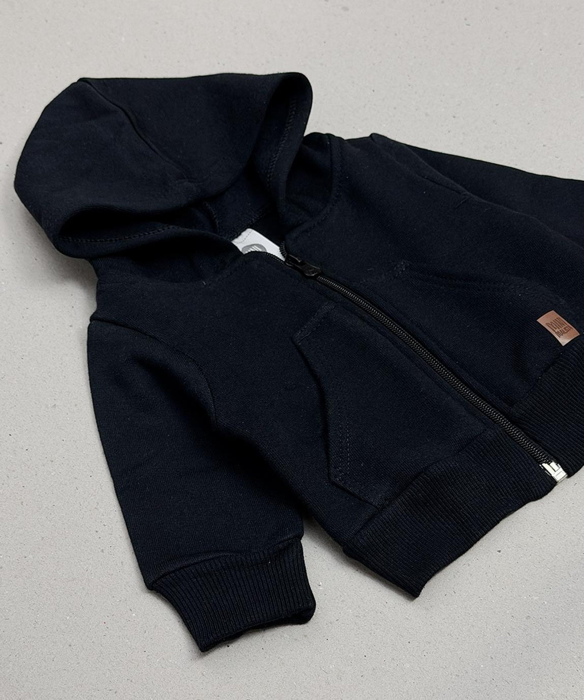 Casaco Moletom Peluciado Liso Preto MiniMalista Baby — vista lateral do casaco infantil unissex em preto clássico atemporal. 100% algodão antialérgico, capuz peluciado sem cordinha, corte folgado pra usar sobre body canelado. Menino, menina ou unissex, do bebê aos 5-6 anos.