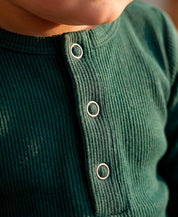 Body Canelado Manga Longa Bebê Liso Deep Green MiniMalista — placket frontal com botões metálicos elegantes, botões entrepernas facilitando troca de fralda, algodão canelado respirável fitted.