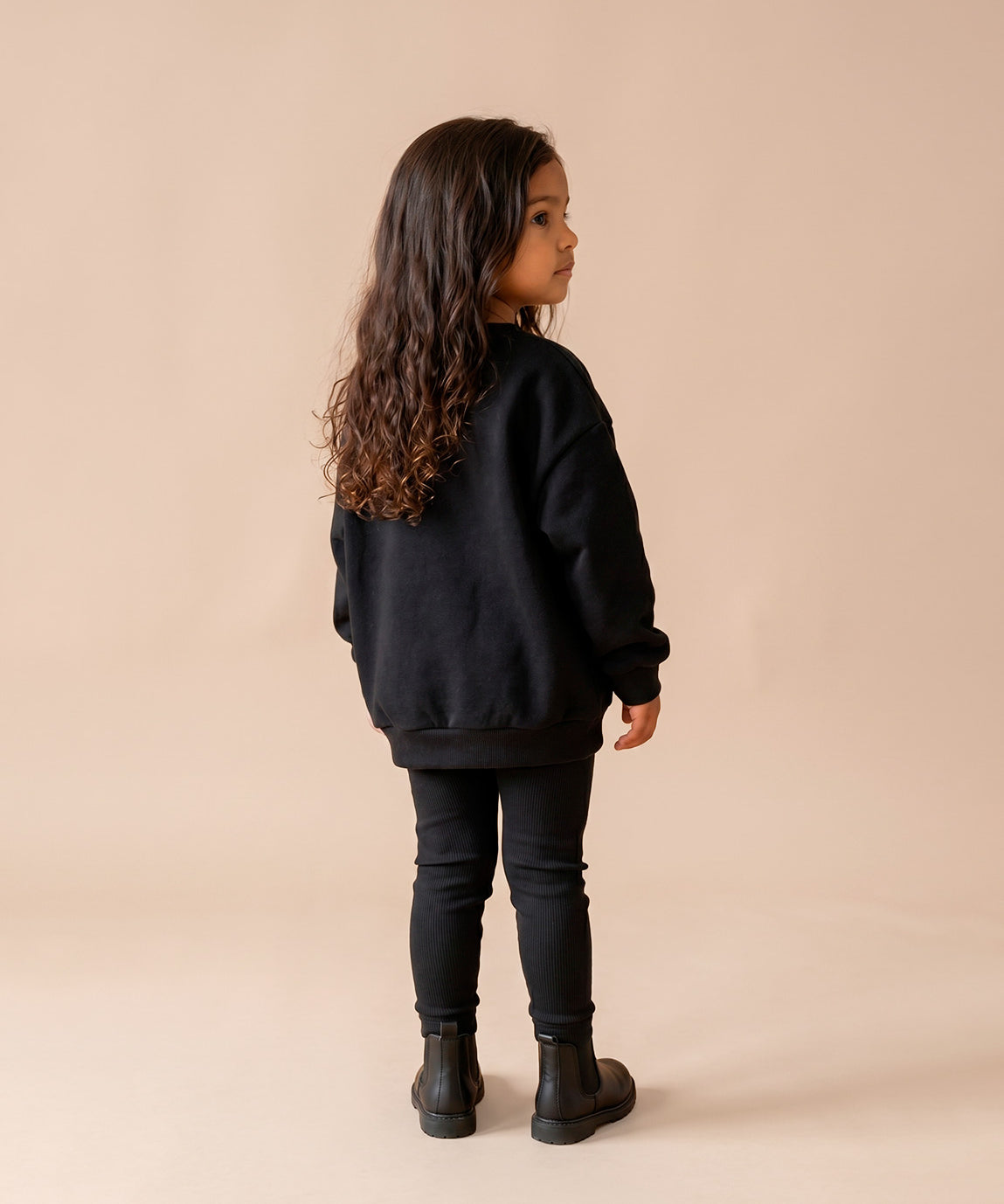 MiniMalista Conjunto Moletom + Calça Canelada Liso Preto vestido em criança. Look elegante infantil 100% algodão, moletom peluciado e calça canelada slim no mesmo tom, conjunto unissex menino e menina.