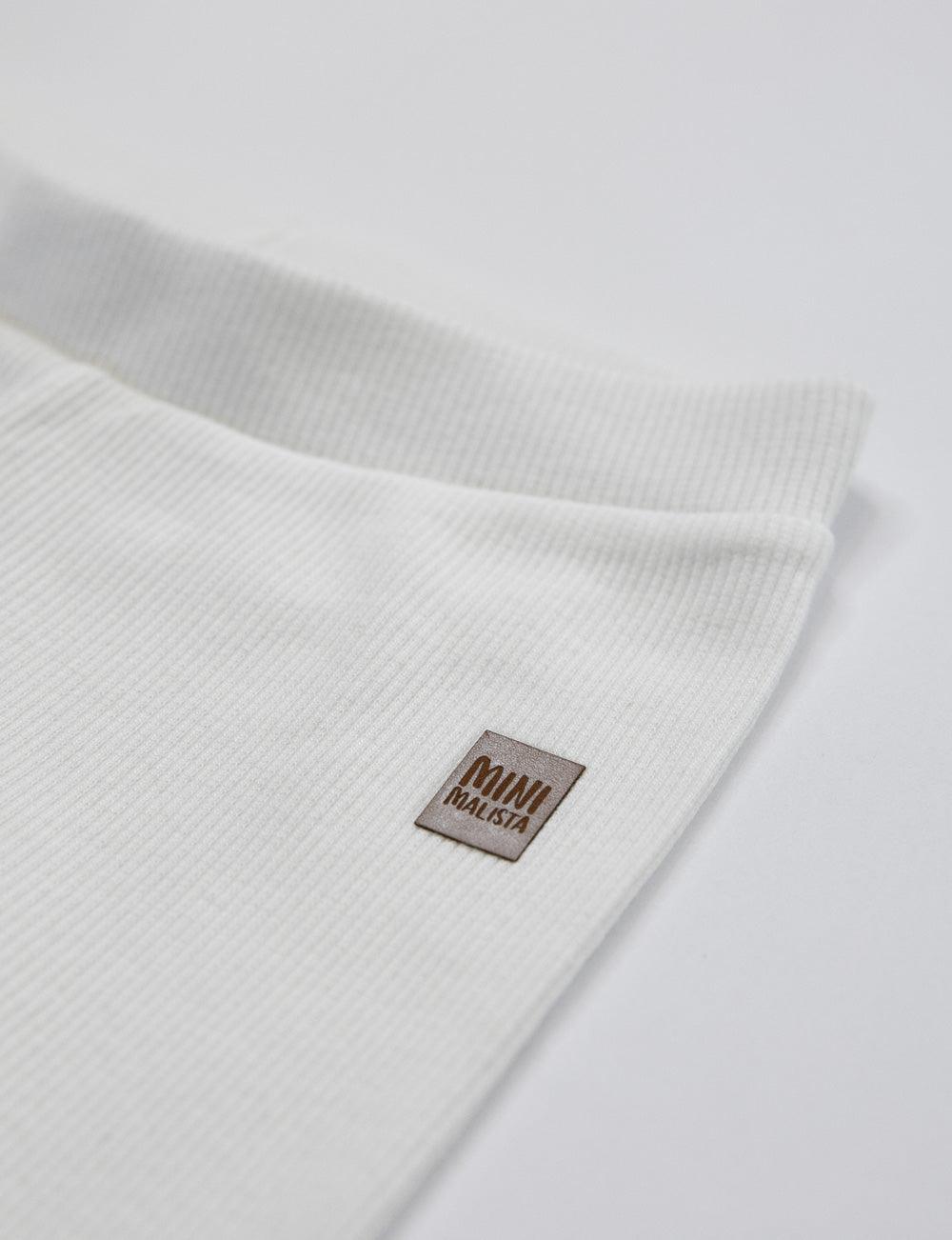 Calça Canelada Slim Liso Branco Off MiniMalista vista lateral — calça infantil 100% algodão em ribana elástica, look minimalista escandinavo all-white para bebê e criança unissex, base coringa do guarda-roupa.